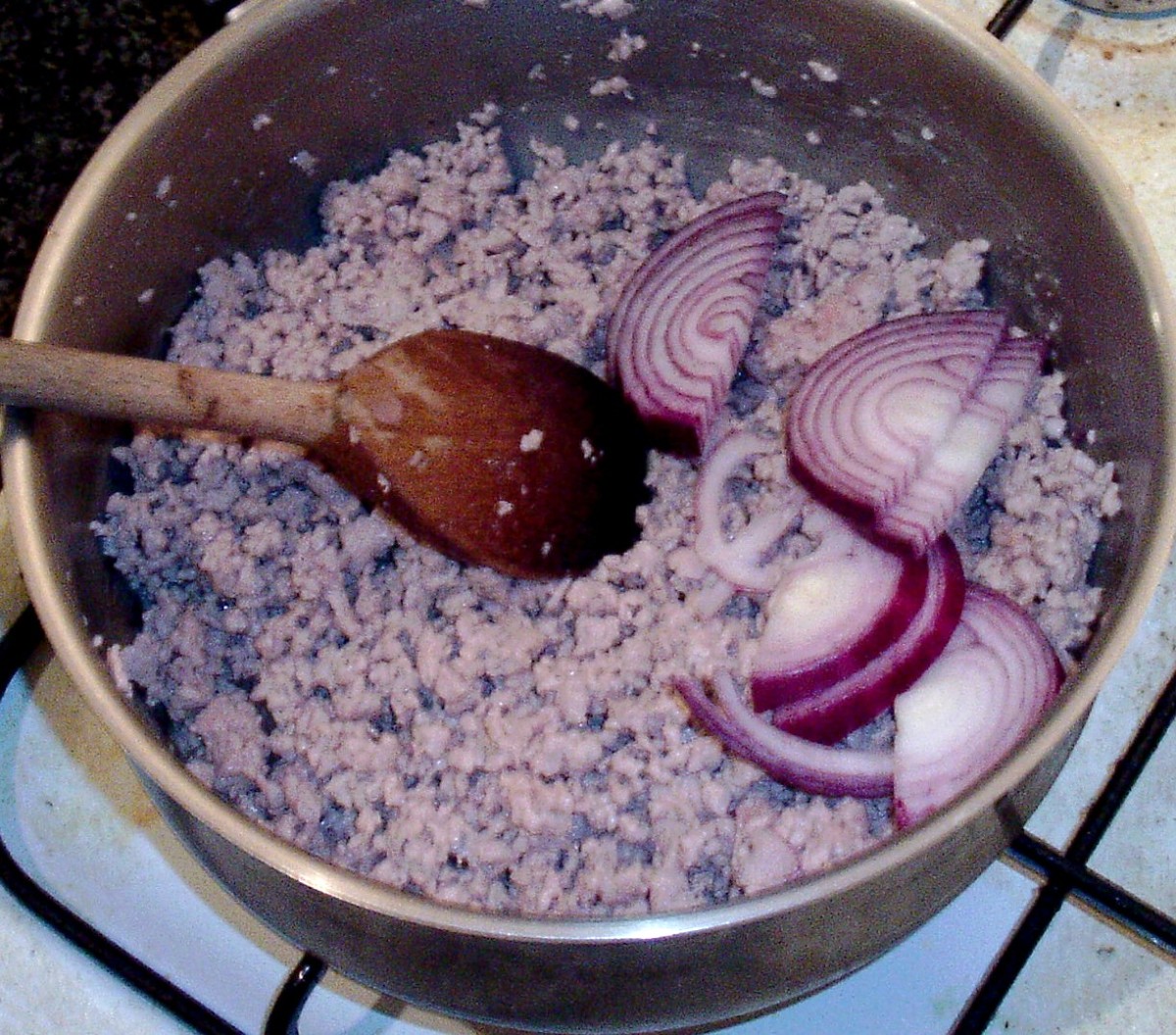 Sliced red onion is added to browned pork
