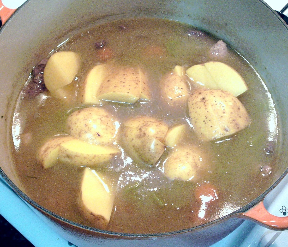Chunks of potato are added to part cooked stew