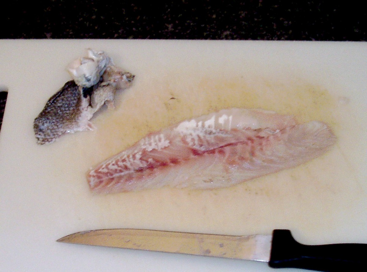 Skin is carefully removed from the sea bass fillet.