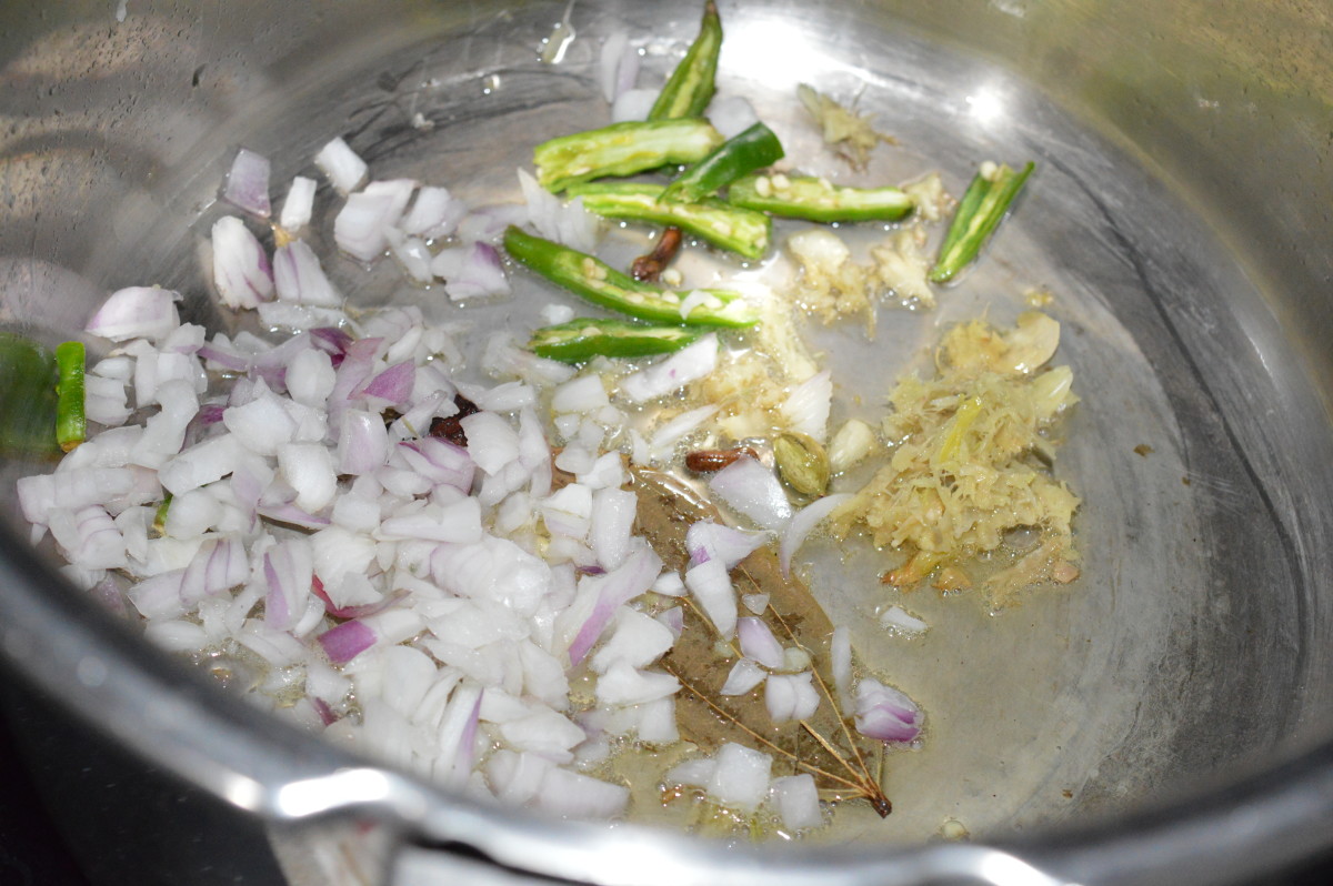 Step three: Throw in chopped onions, ginger-garlic paste, and slit green chilies. Continue sauteing till onions turn translucent.