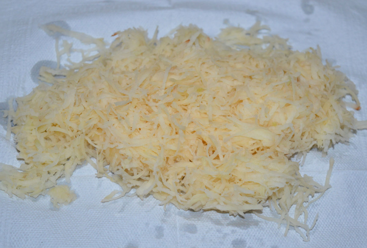 Step four: Place the squeezed potato julienne in a paper towel. Wrap it around and press or pat to dry them up further.