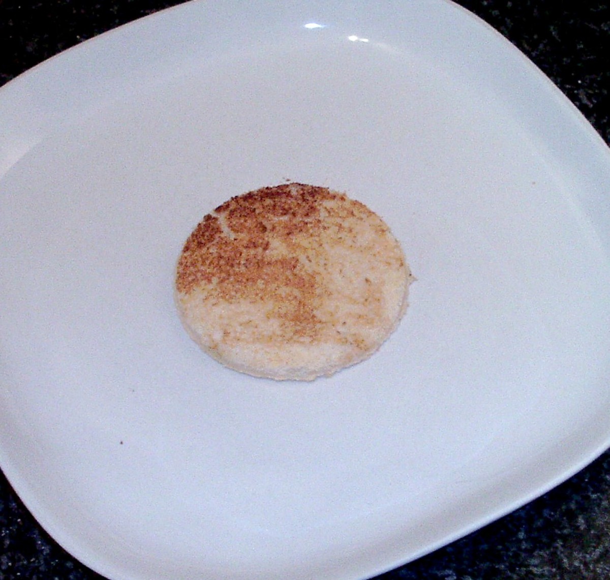 Toast circle is sat in centre of square serving plate.