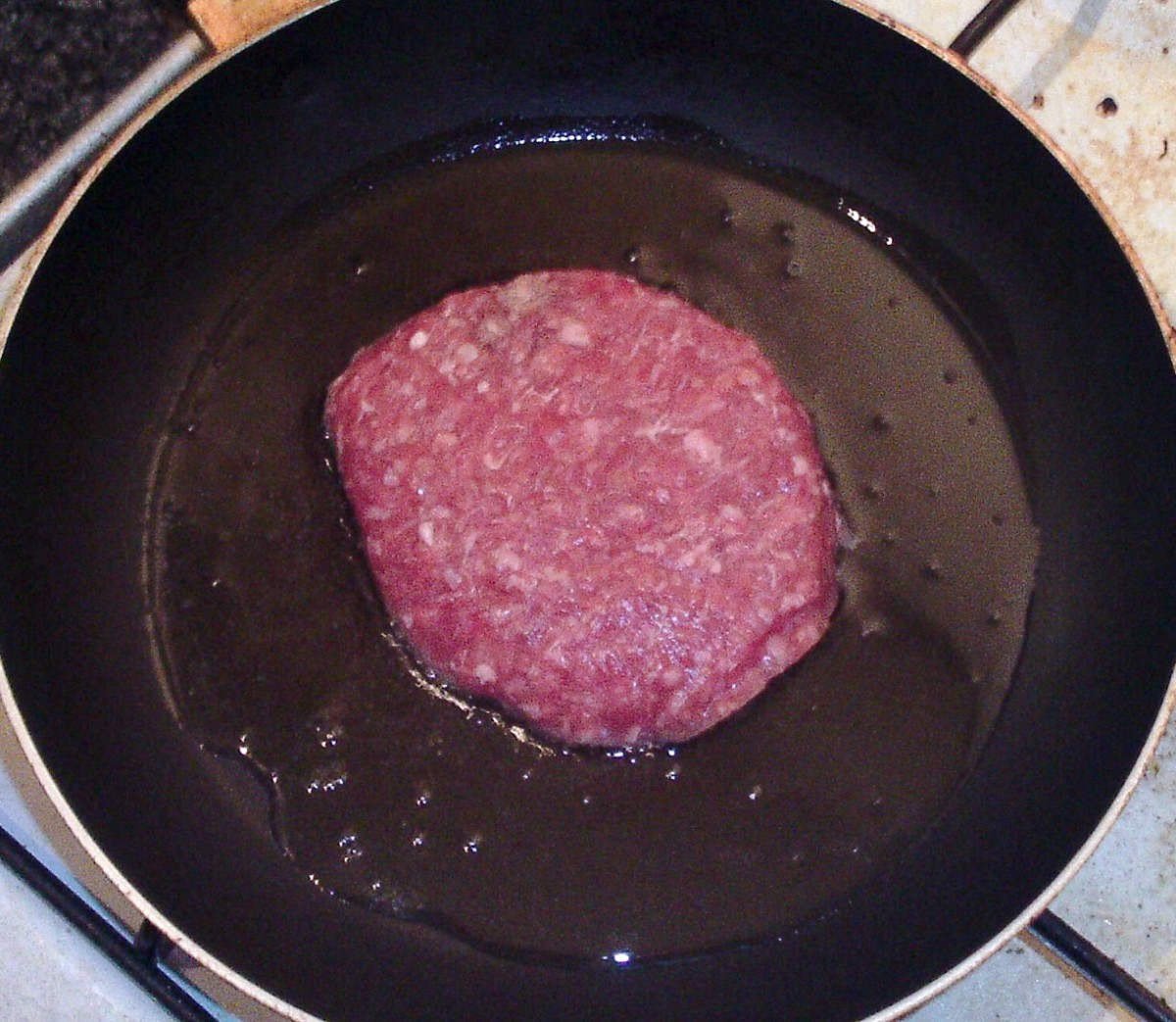 Belgian blue beef burger is put on to fry