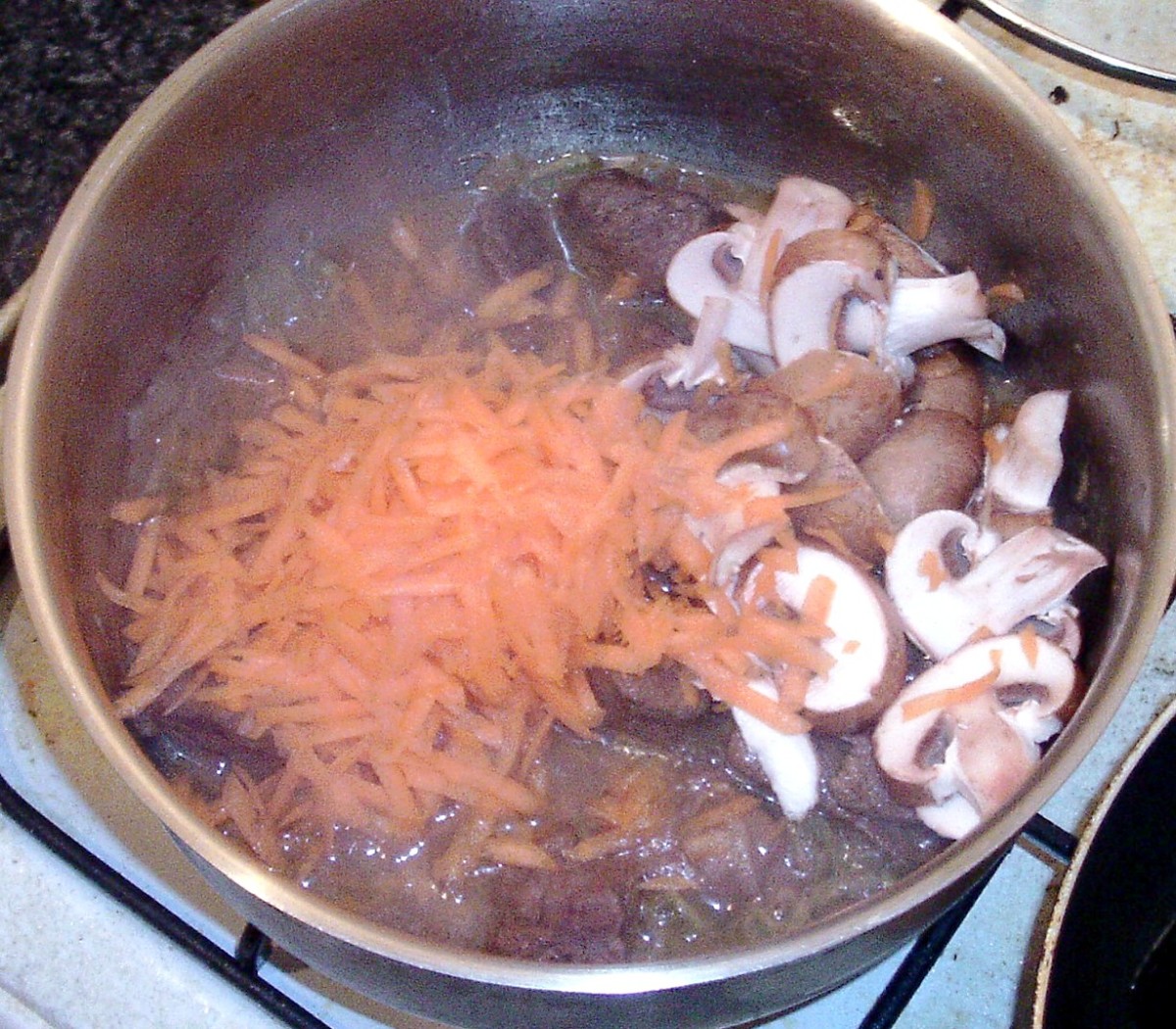 Add grated carrot and sliced mushrooms to stew