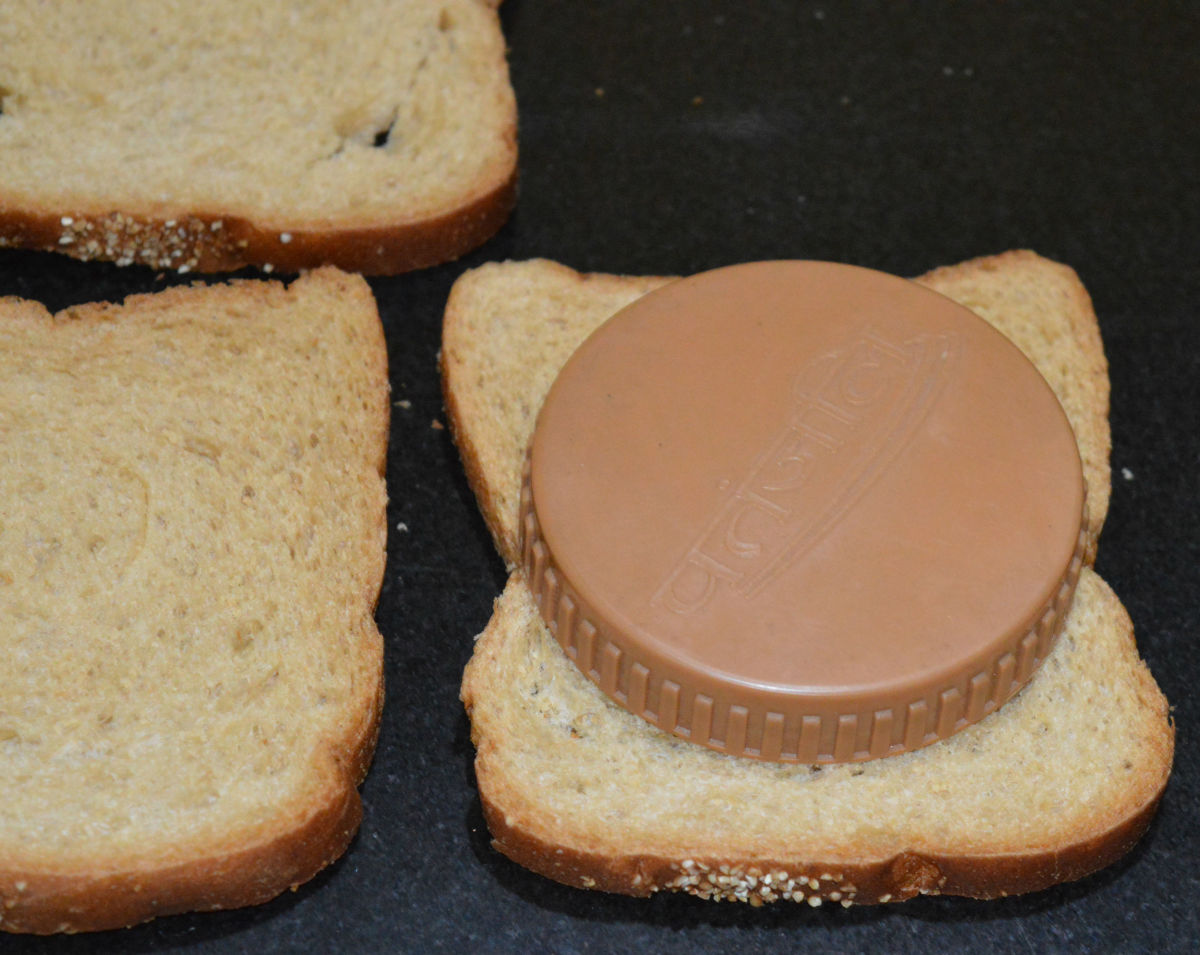 Step one: Place a lid on the bread. Chop the outside portion, so that you get a round shape.