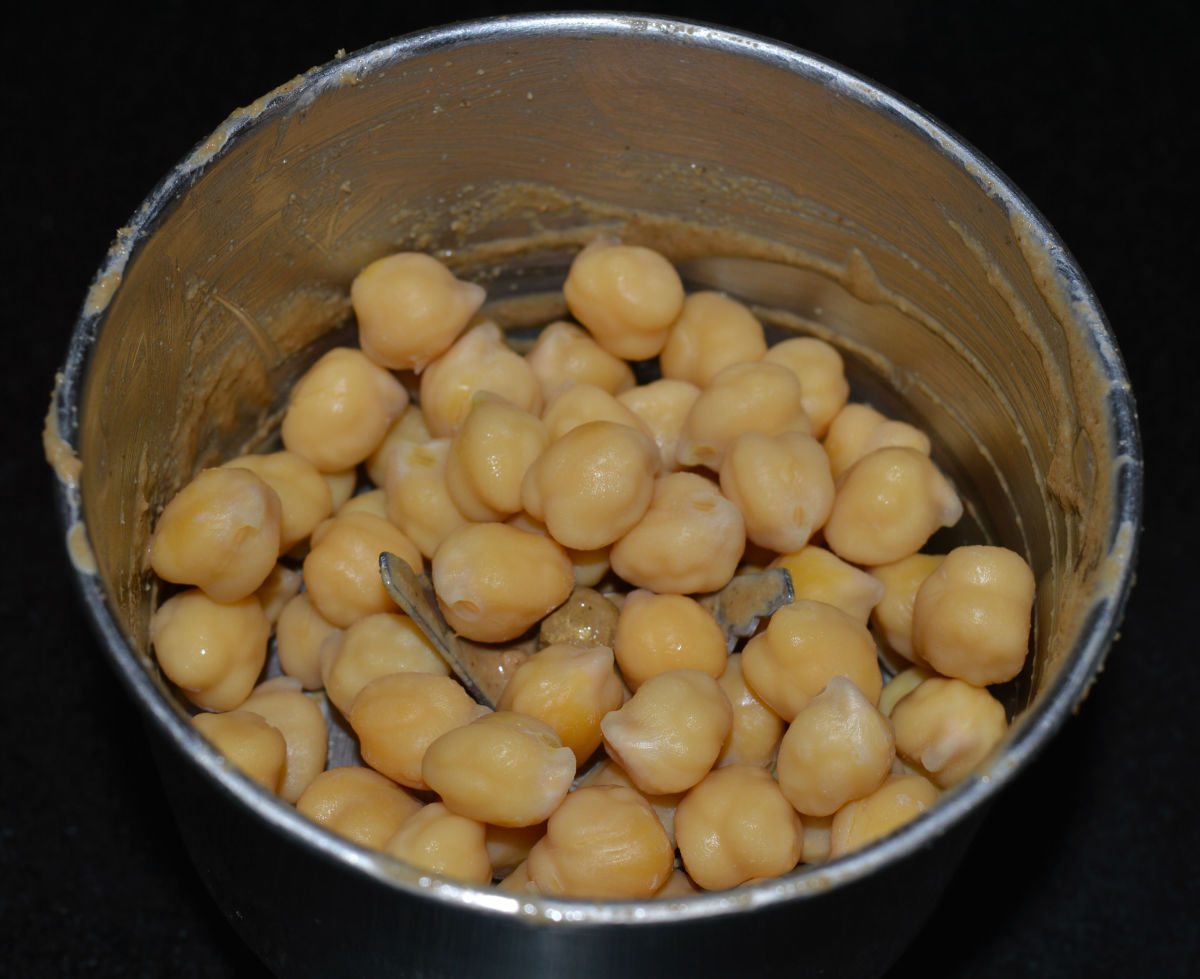 Step two: Put cooked chickpeas into a mixer jar in small batches. This is mainly to enable the mixer to grind smoothly. Add cumin powder, chopped garlic, lemon juice, salt, and some chickpea water. Grind to get a smooth paste.