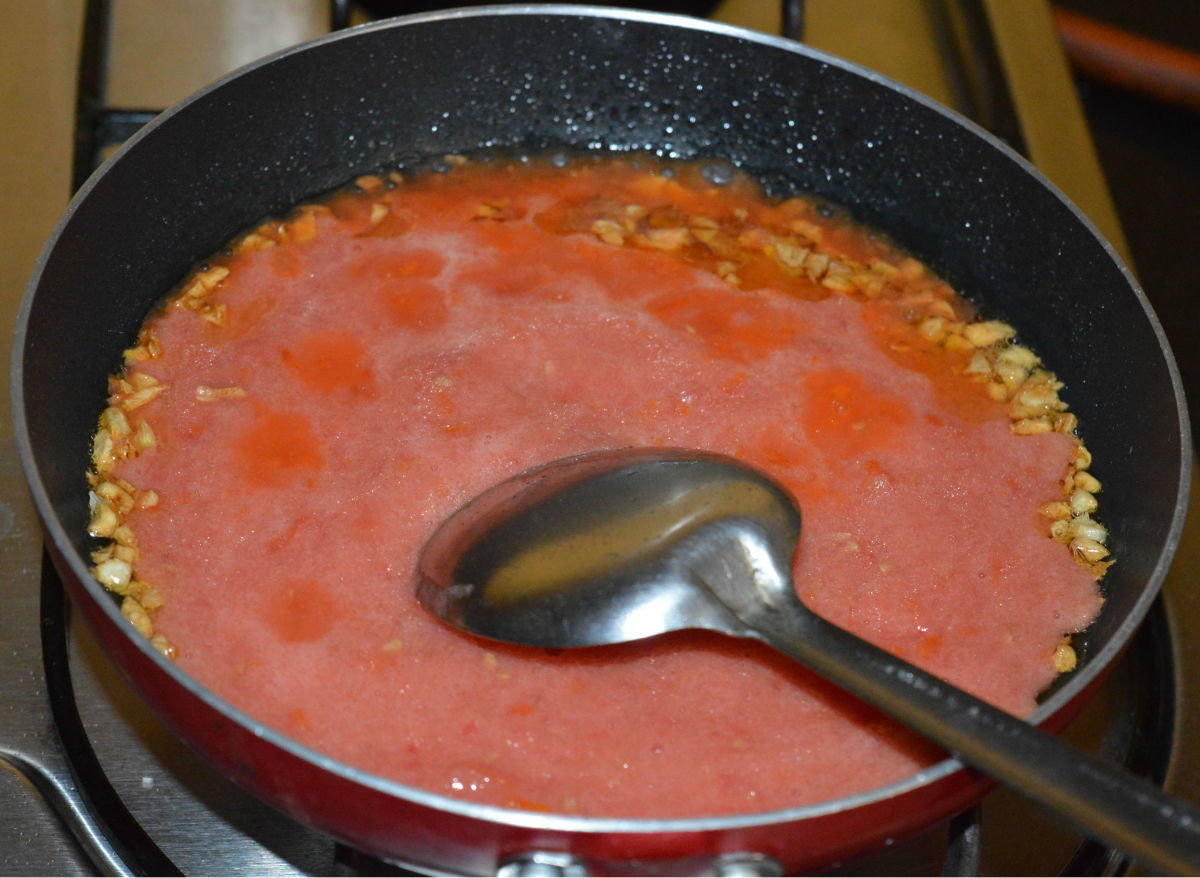 Step three: Add tomato puree. Stir well. Increase the flame. Saute until the puree becomes dry and starts leaving oil on the edges.