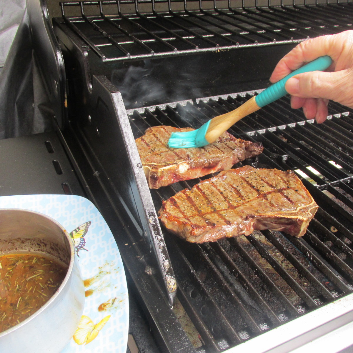 Brushing the homemade steak sauce on the steaks