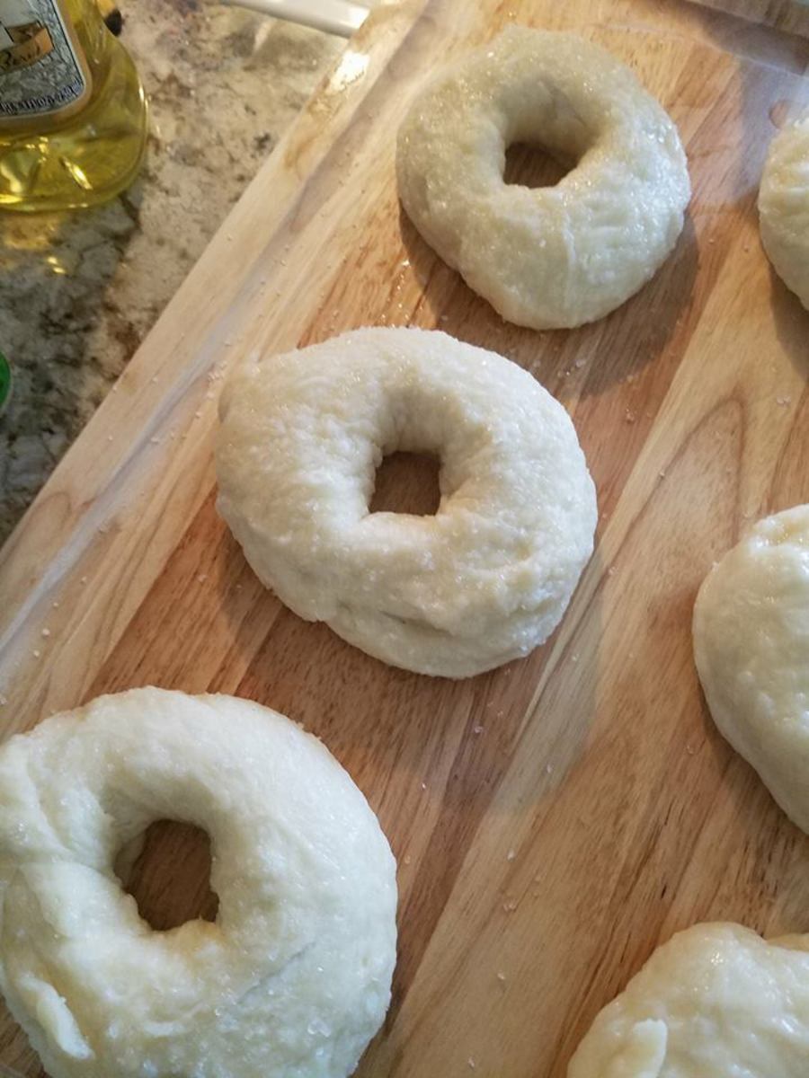 Draining the boiled bagels.