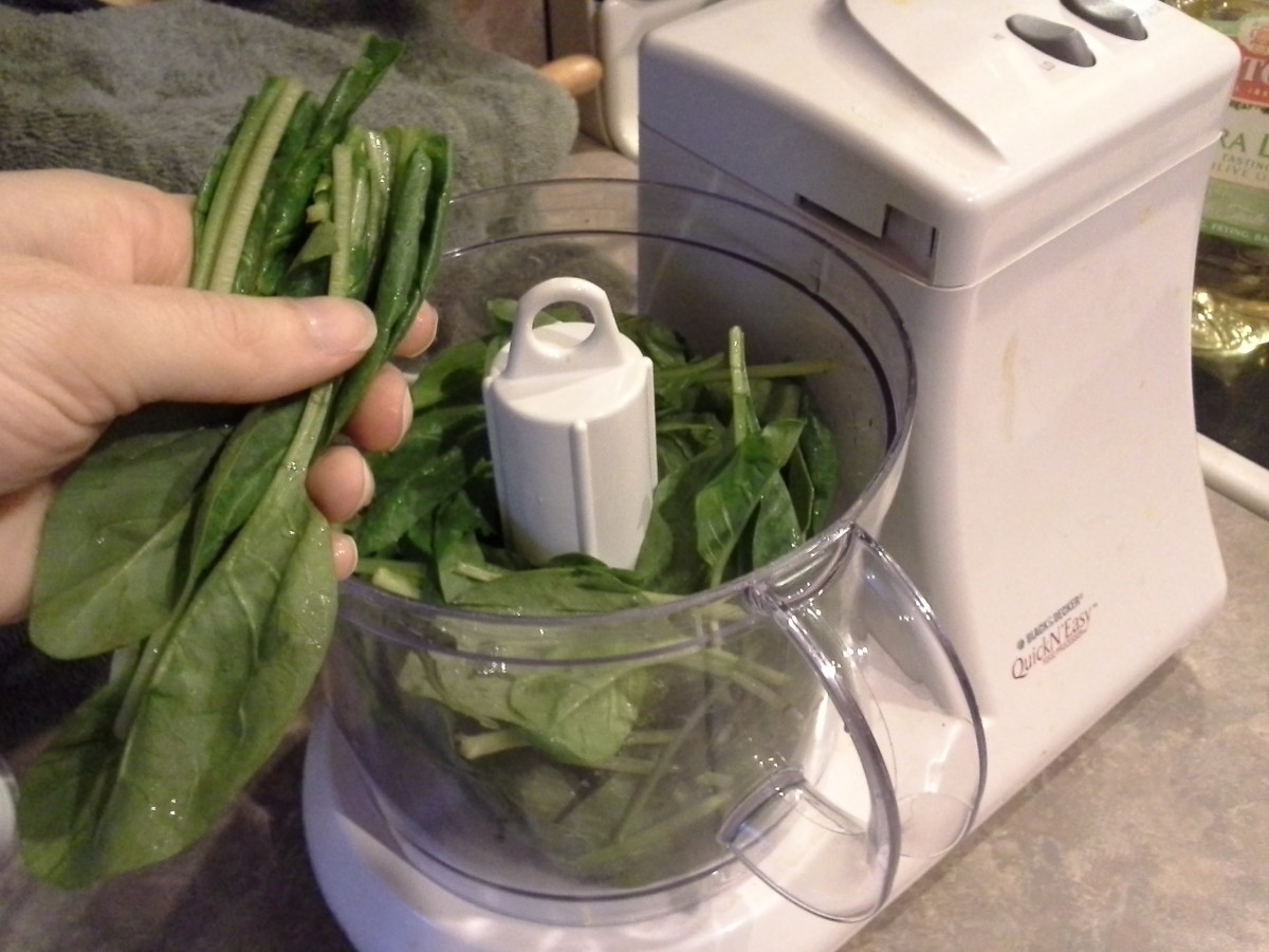 Step Five: Begin your pesto by adding your spinach to the food processor