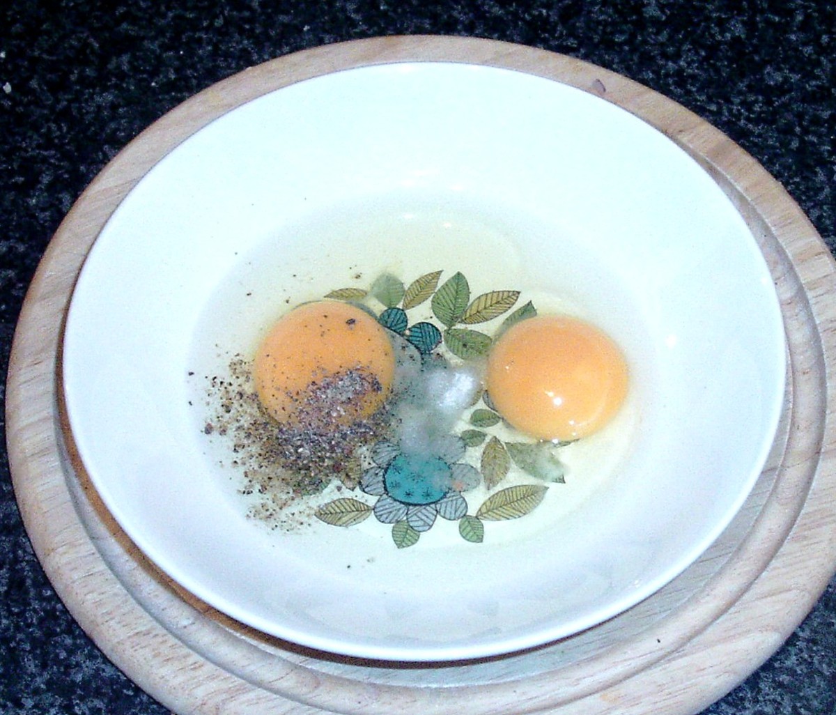 Eggs are broken in to a deep plate and seasoned