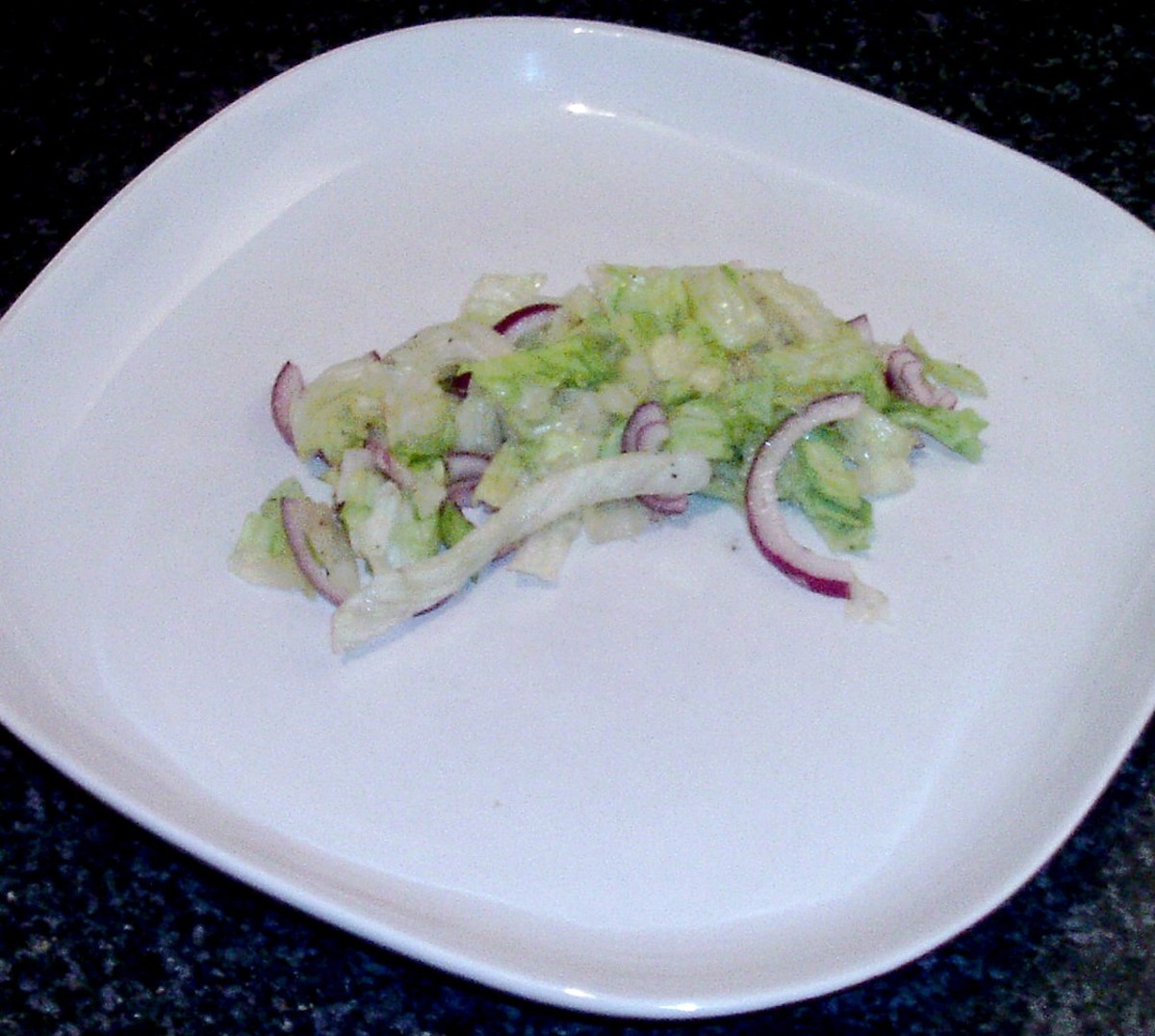 Lettuce and onion sandwich bed is plated