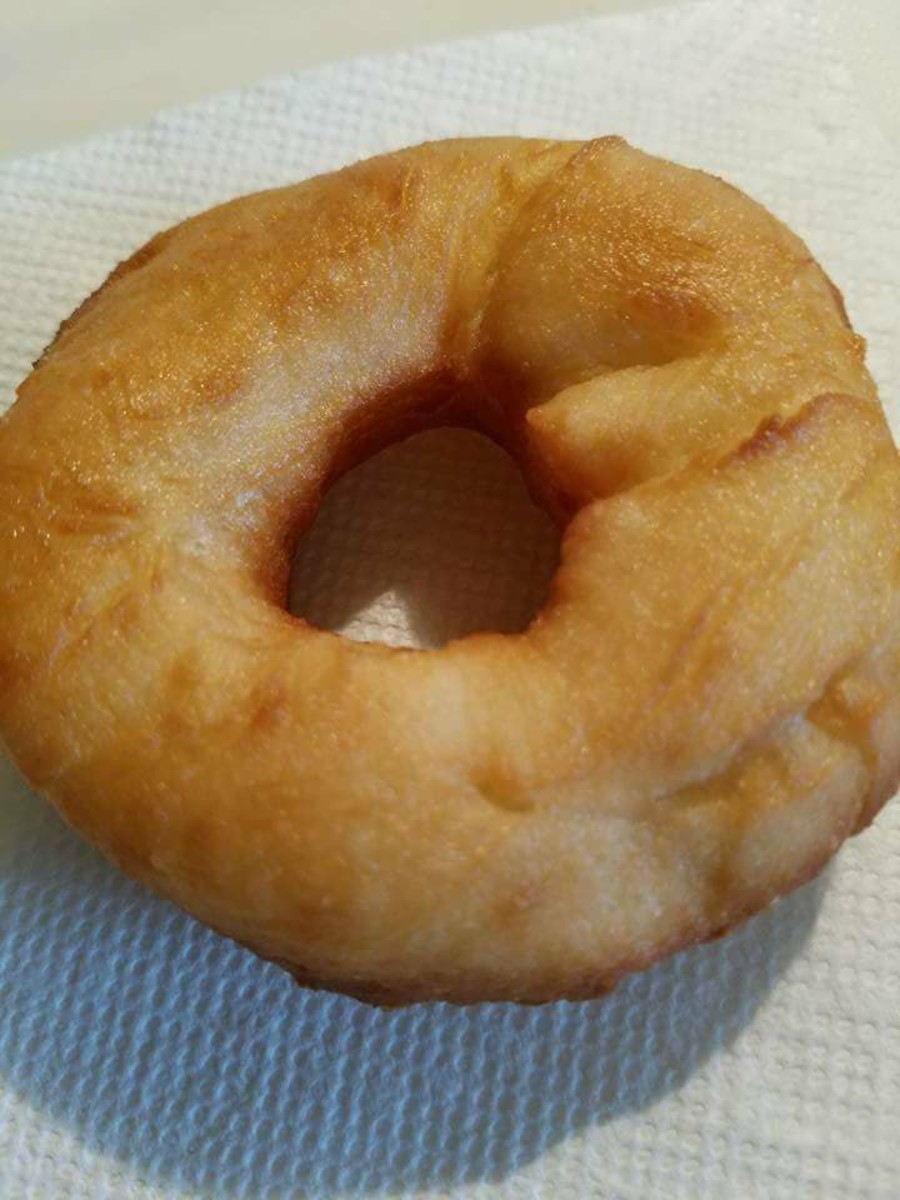 A donut draining on a paper towel