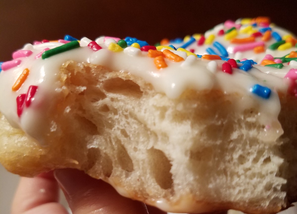 A donut with vanilla icing and sprinkles.