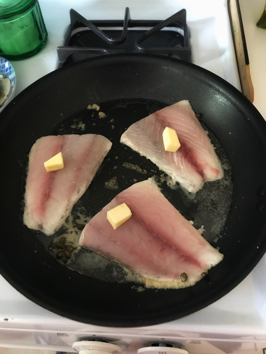 Cooking the fish with some butter.