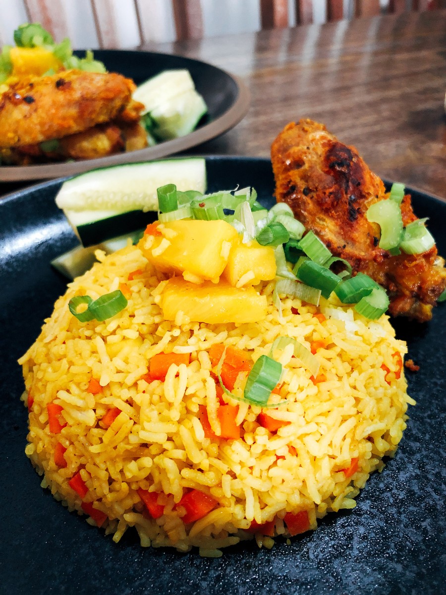 Pineapple fried rice served with fried chicken. 