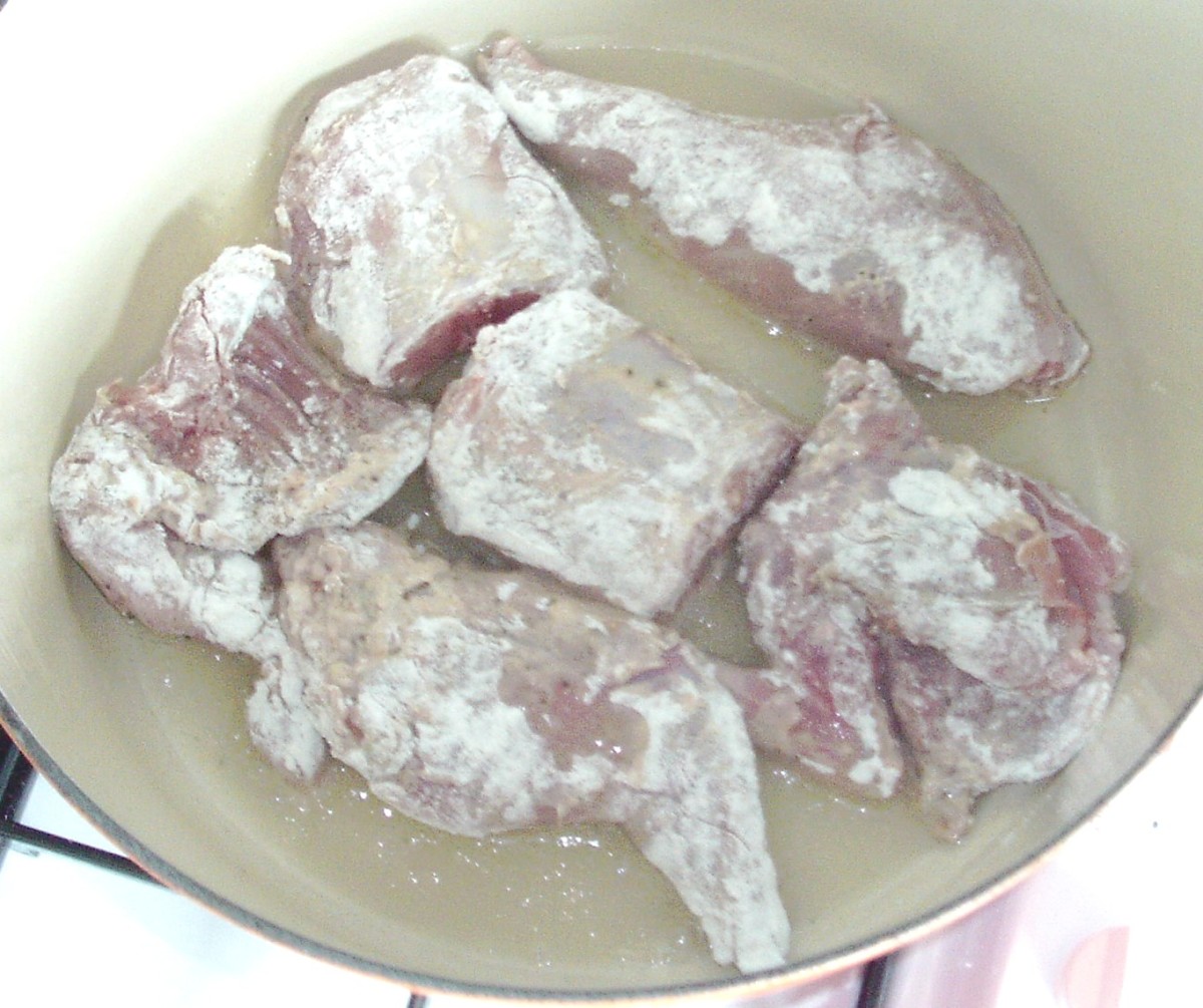 Floured rabbit and squirrel pieces are browned in batches.