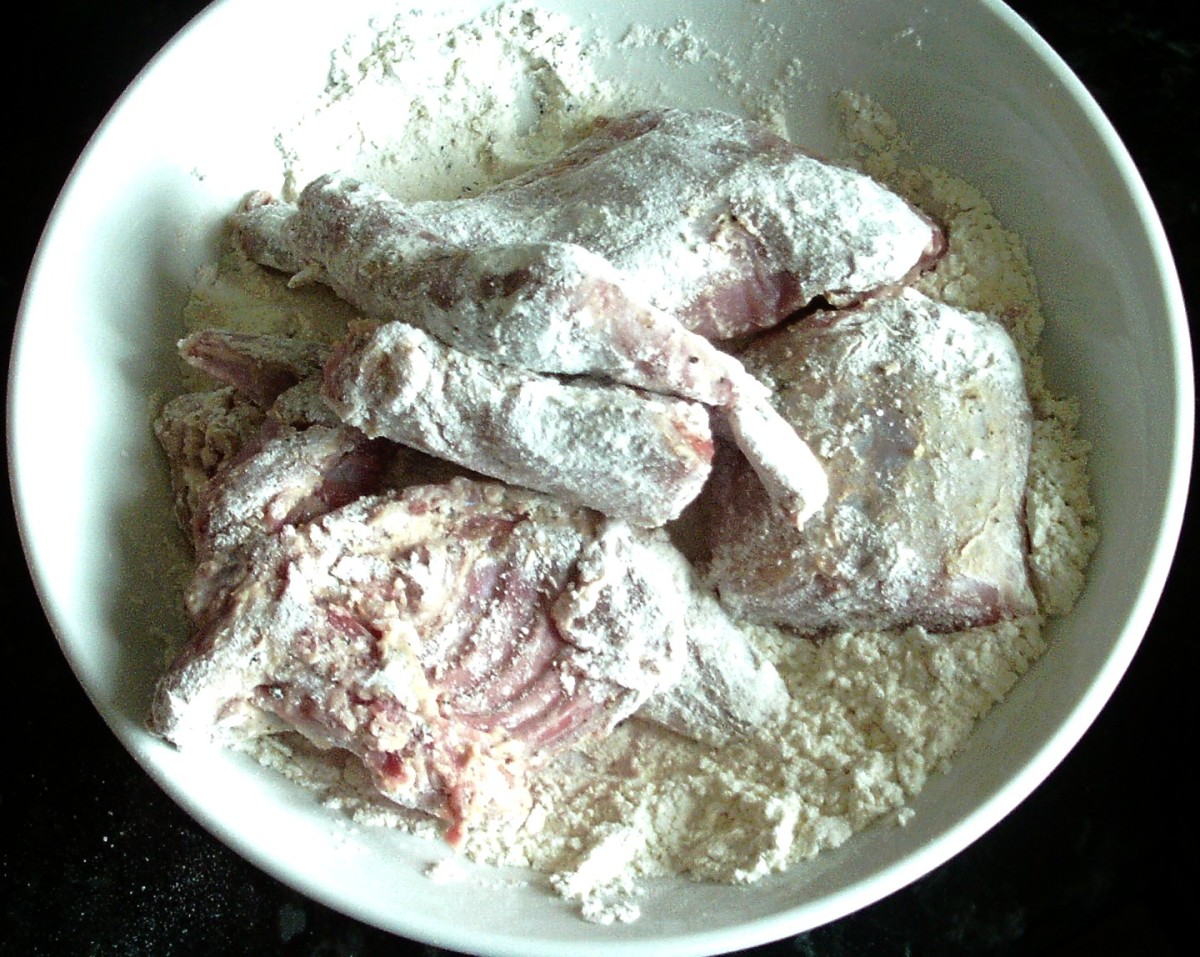 Rabbit and squirrel portions are turned in seasoned flour.