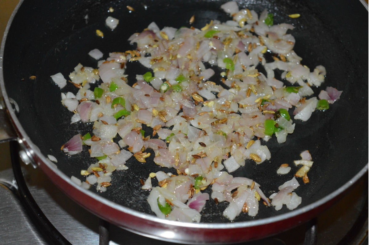 Step two: Add chopped onions and green chilies. Saute until onion turns pinkish.