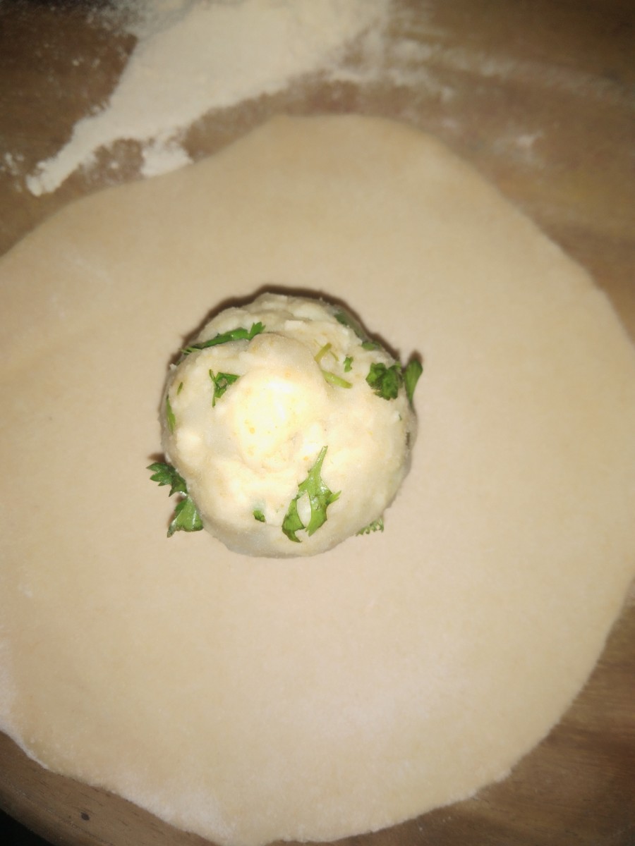 Take one ball of dough, roll it out, and place the stuffing in the center of the dough.