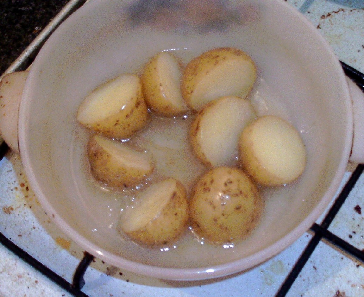 Boiled and cooled potato halves are added to hot oil.