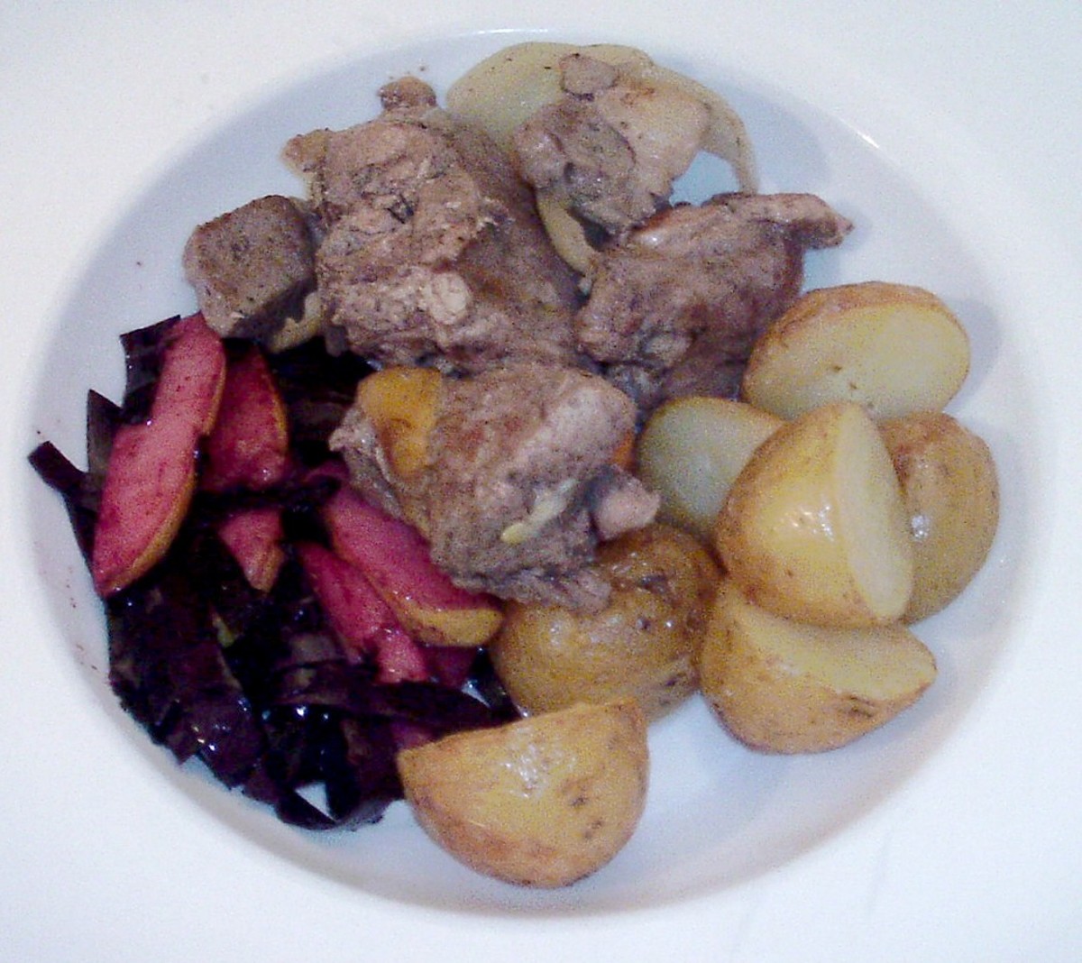 Pheasant and lamb stew is plated with roast potatoes, red cabbage and pear