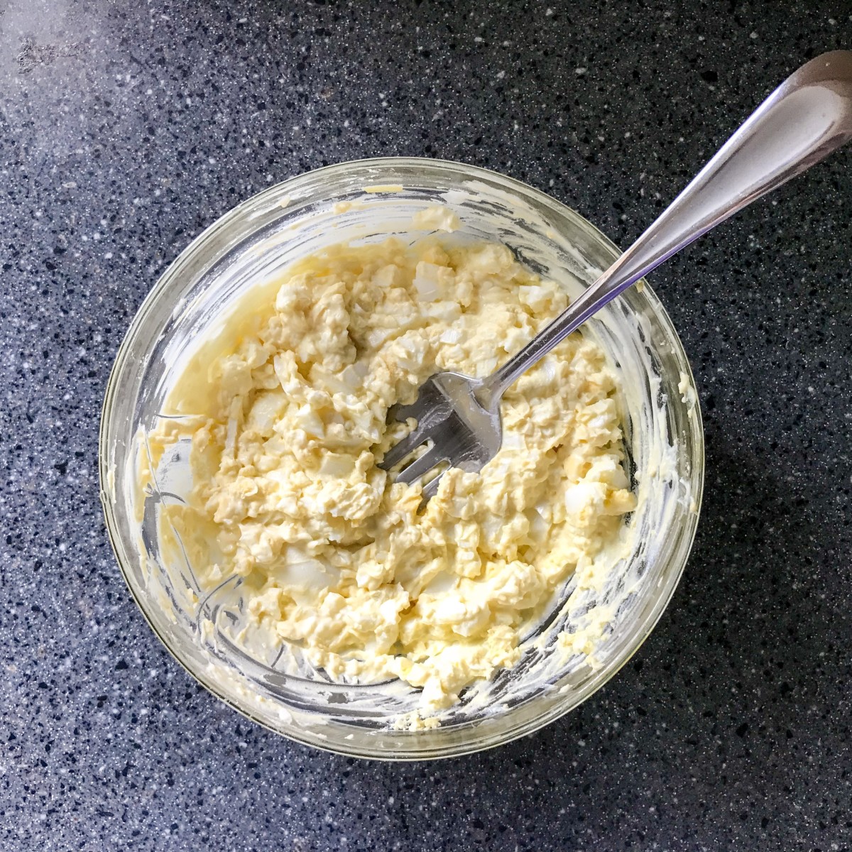 Use a fork to mash together eggs and mayo.