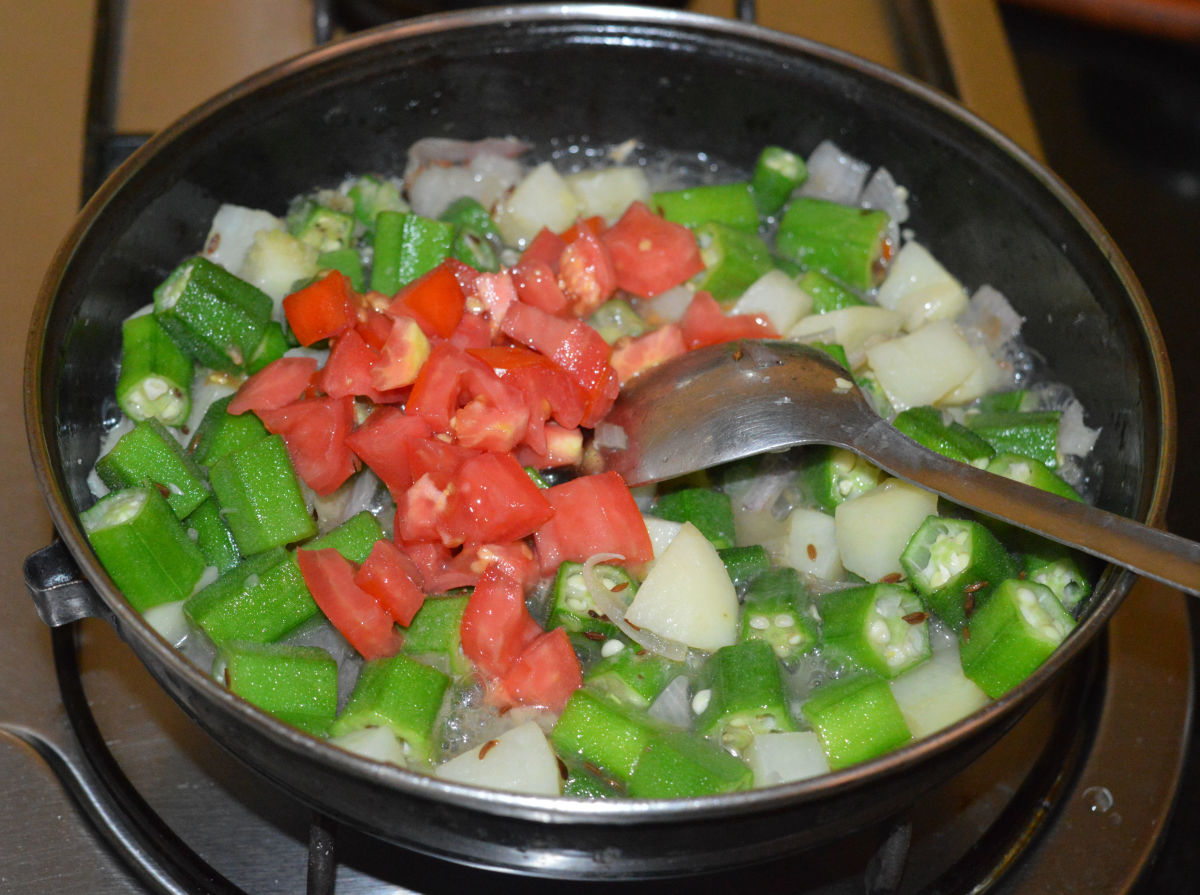 Step four: When the veggies cook halfway through, add chopped tomatoes. Continue cooking until tomatoes become a bit mushy.