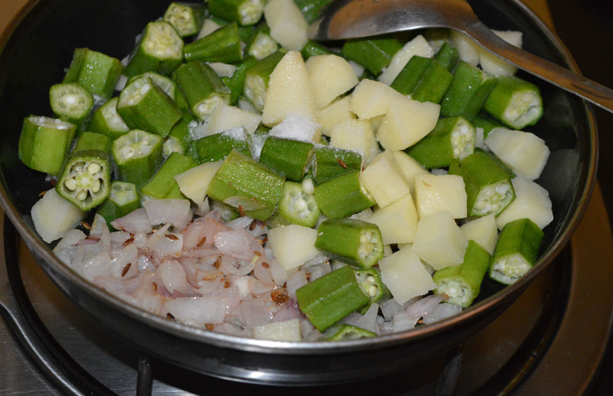 Step three: Add potato cubes and okra pieces. Add some salt. Saute over low flame for two minutes.