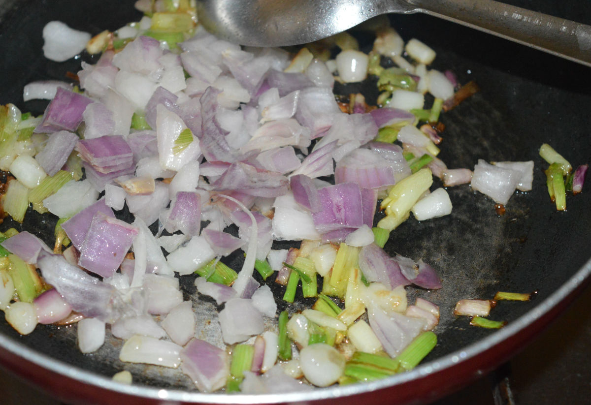 Step one: Saute chopped onions and spring onion whites in oil until they turn pinkish.
