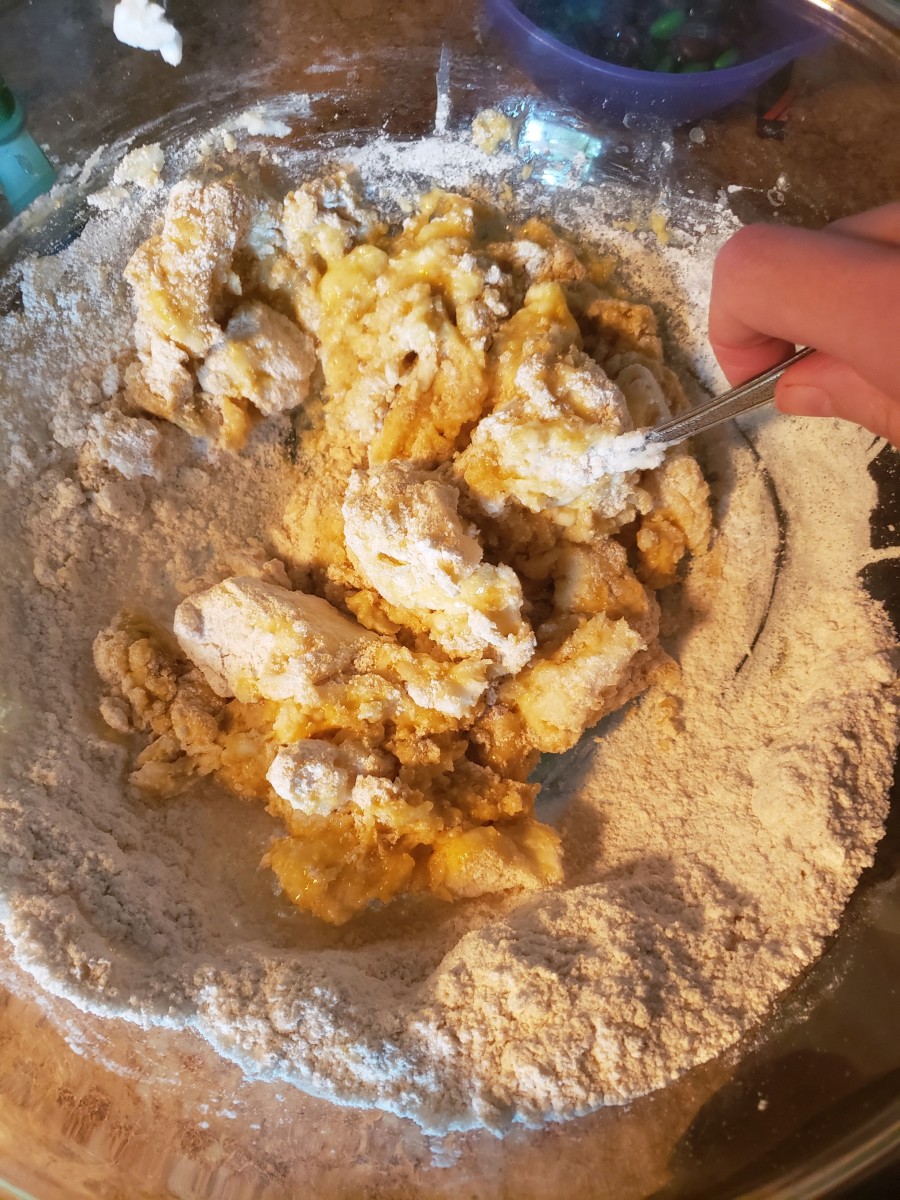 Slowly mix dry ingredients into the shortening, egg, vanilla extract mixture until it starts to clump. Set fork aside and knead the clumps with your hands into dough.