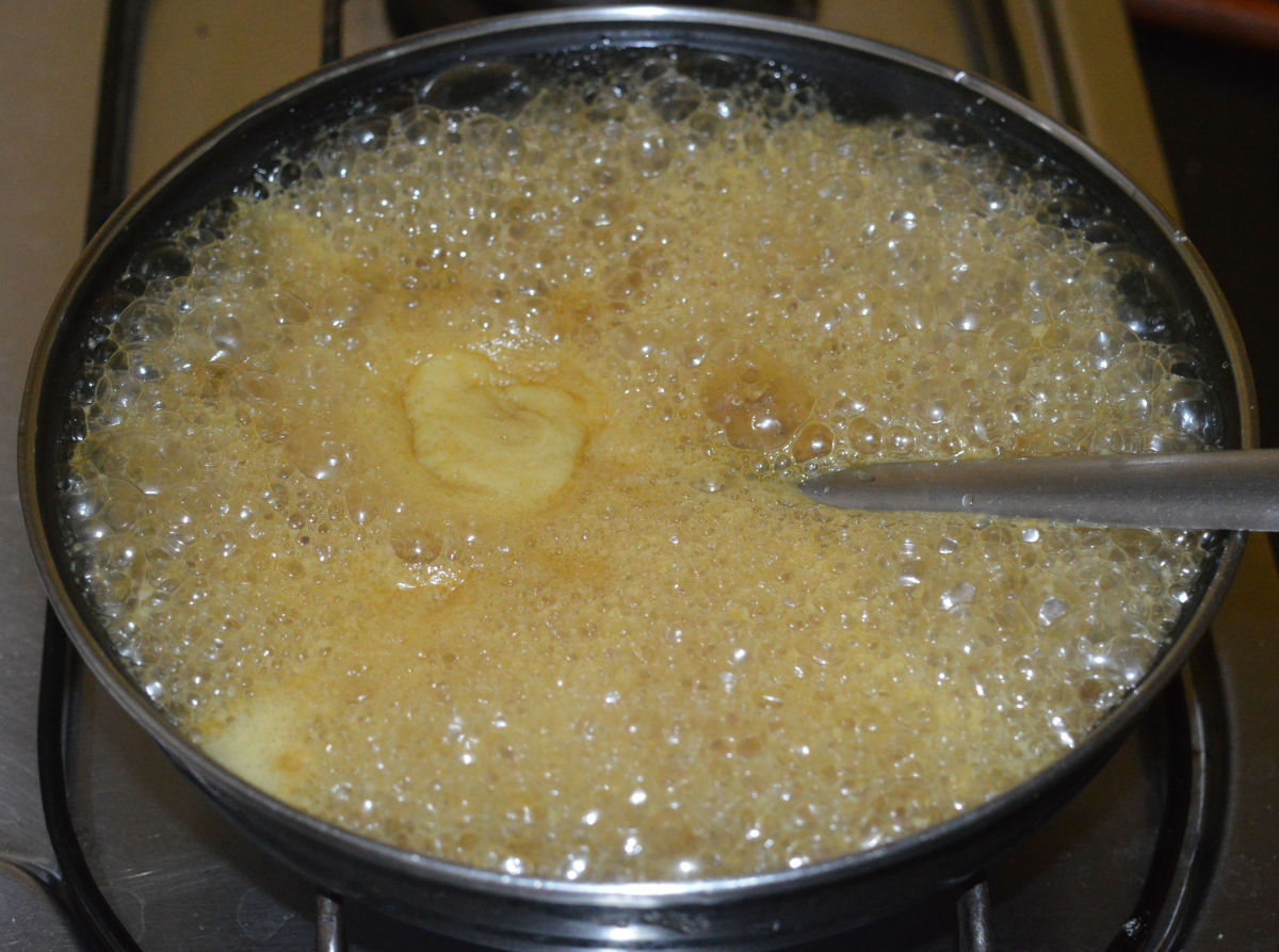 After some time, the jaggery melts and the mixture becomes liquid.