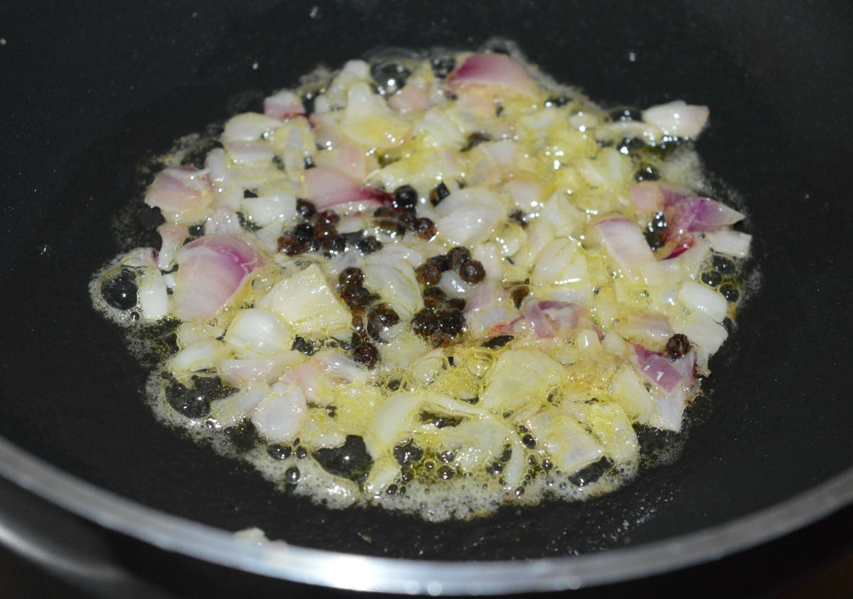 Step one: Add butter, black peppercorns, and chopped onions to a deep-bottomed pan. Heat it. Saute for 1 minute.