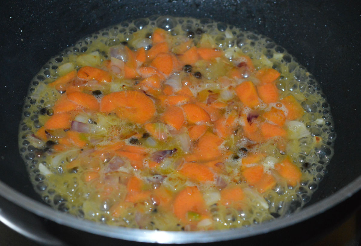 Add some water and cover the pan. Cook on medium heat until the carrots become soft.