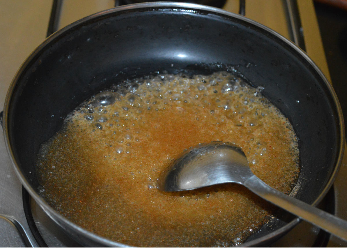 Heat it. Add a very small amount of water and saute the contents until the sugar melts completely.