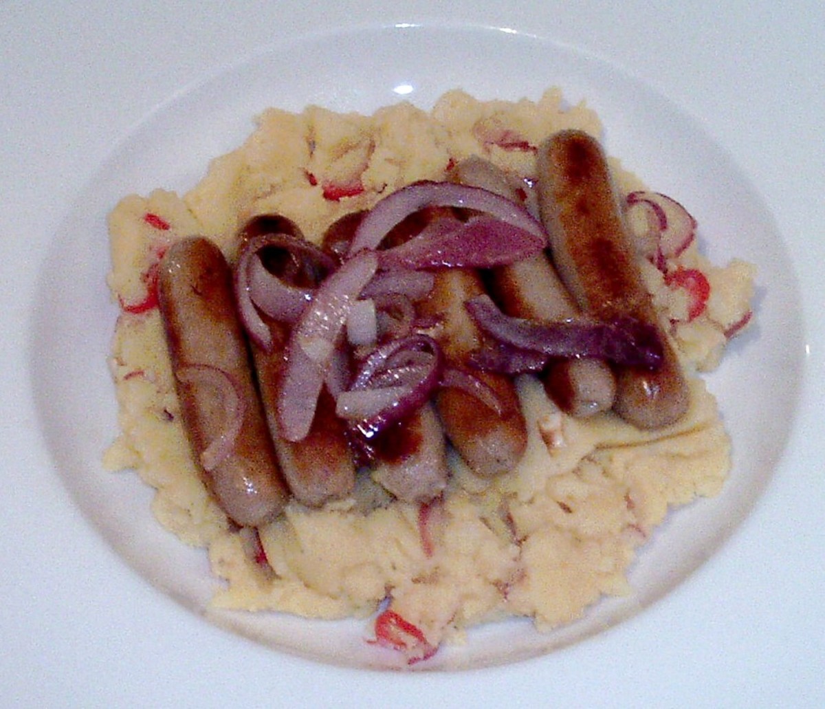 Sausages and fried onions on chilli and mustard mash