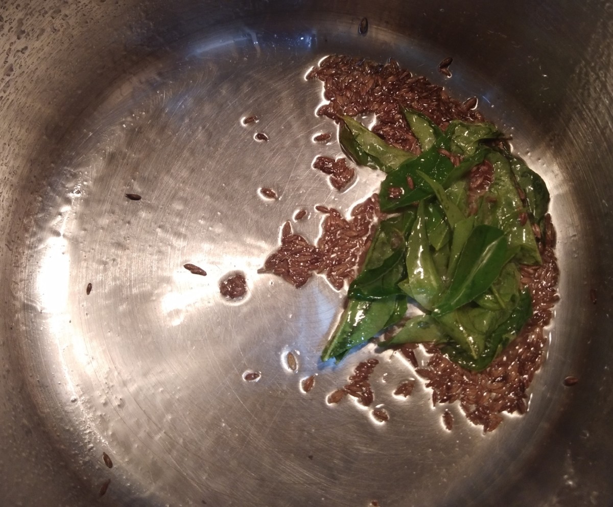 In a pan or pot, heat the oil. Add the cumin seeds and let them splutter. Add the curry leaves and fry.