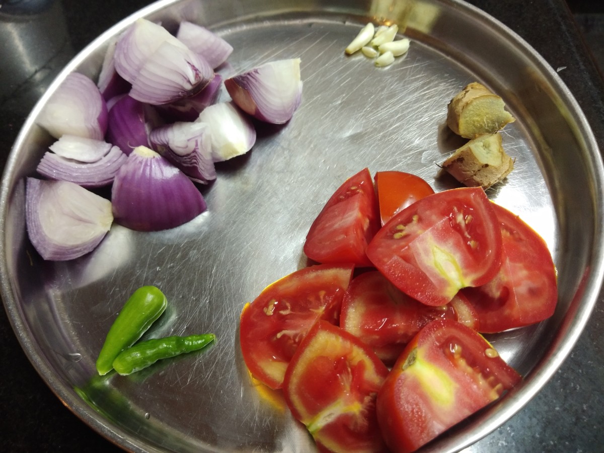Roughly chop the onion and tomatoes. Take ginger, green chilies, peeled garlic and set aside.