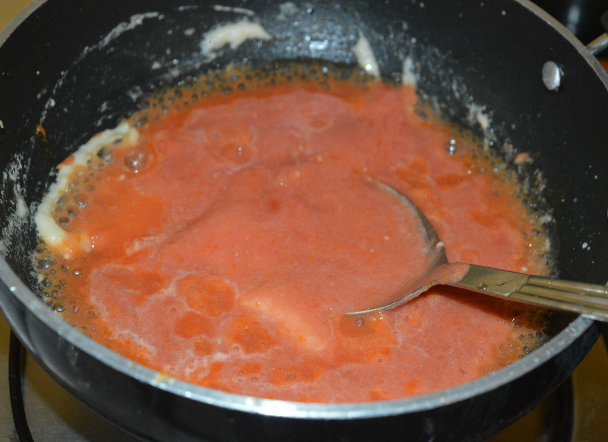 Step five: Add tomato puree and some salt. Increase the heat. Mix well.