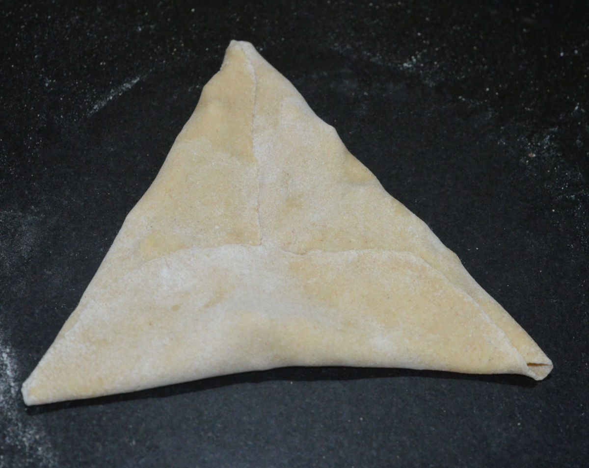 Fold the lower half portion to join the upper portion. Now, you get a triangle-shaped stuffed paratha.