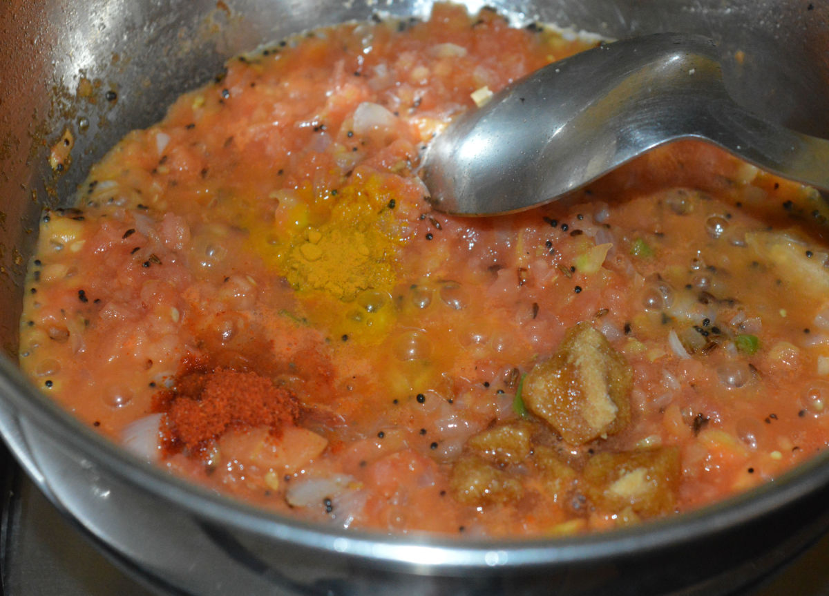 Step four: Add jaggery powder, turmeric powder, and red chili powder. Continue to cook the mixture until the tomatoes cook completely and the mixture gets a semi-solid consistency.