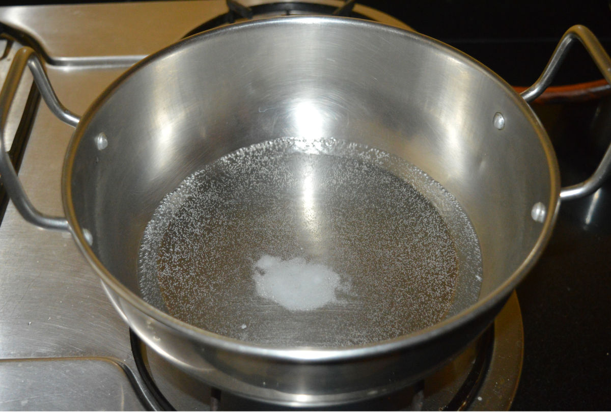 Step four: Heat water in a deep-bottomed pan. Add salt. Let the mixture come to a gentle boil.