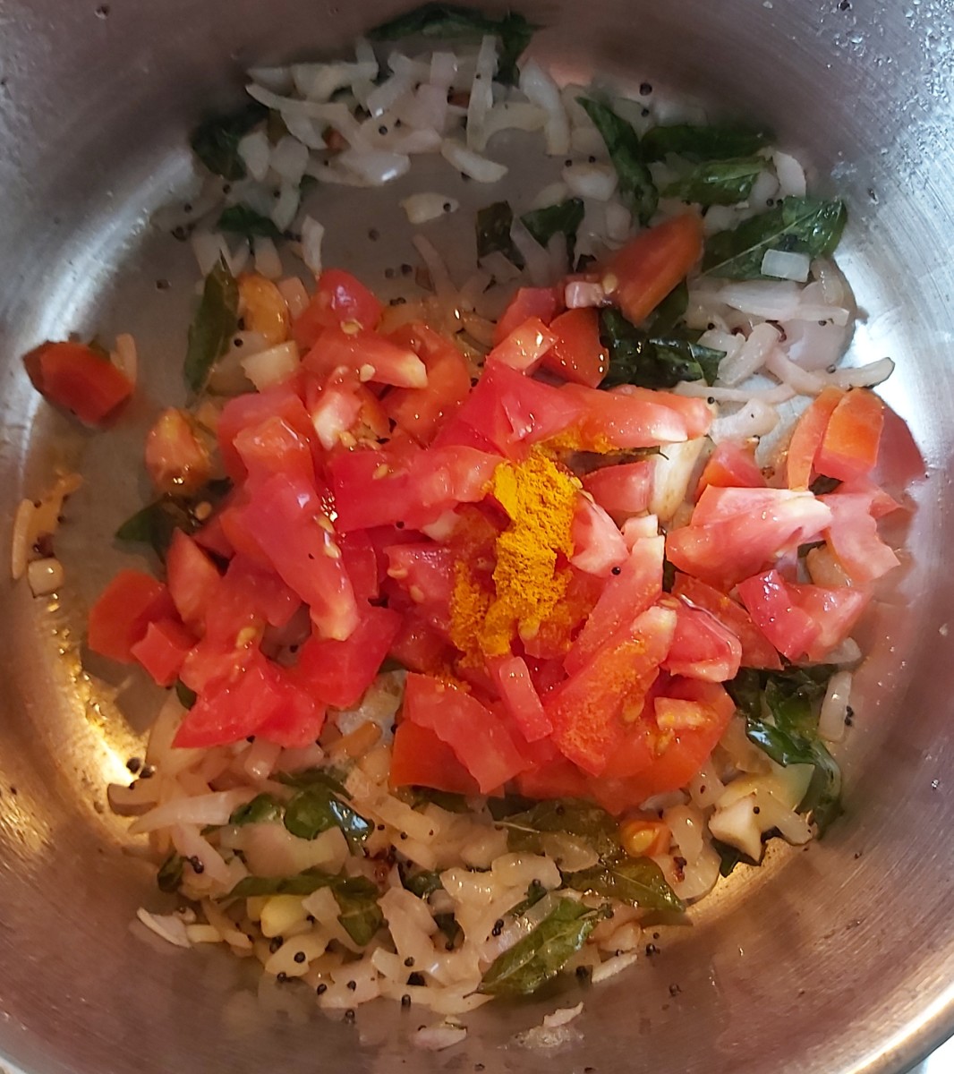 Add chopped tomatoes and 1/4 teaspoon of turmeric powder.