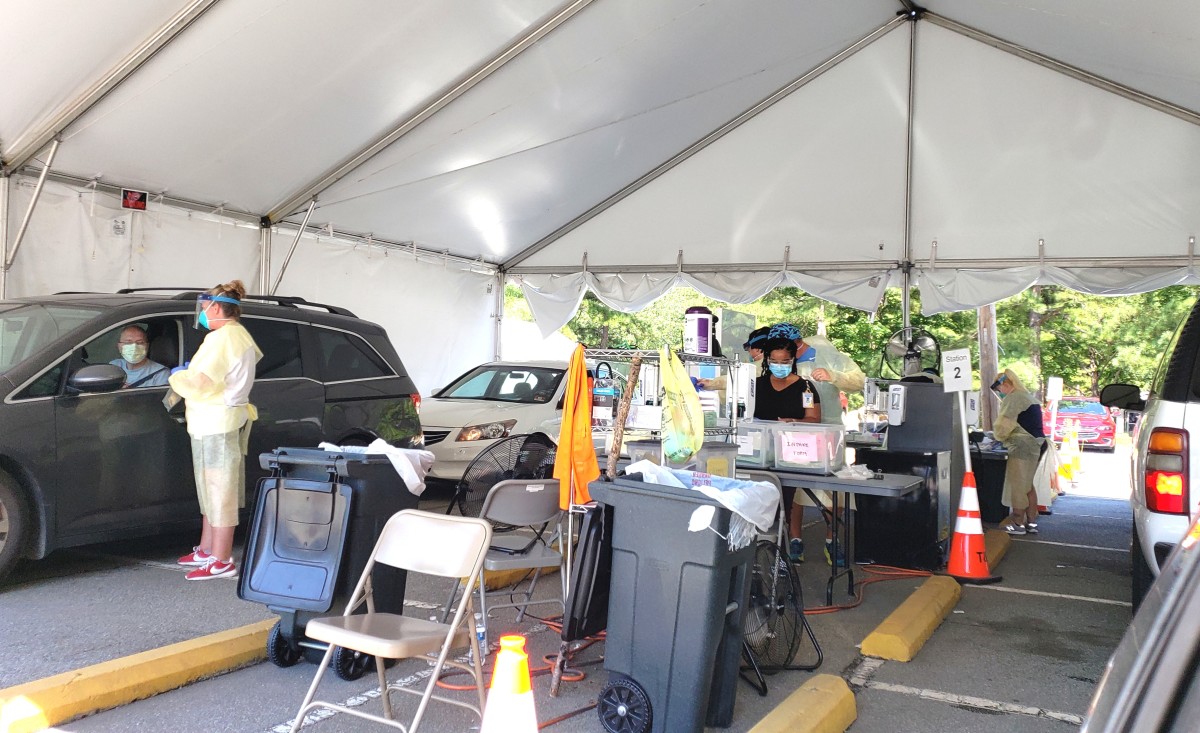 An example of a drive-thru COVID-19 testing site in North Carolina on 7/15/20, where medical professionals approach vehicles and collect a nasal swab from patients who remain in their vehicle.