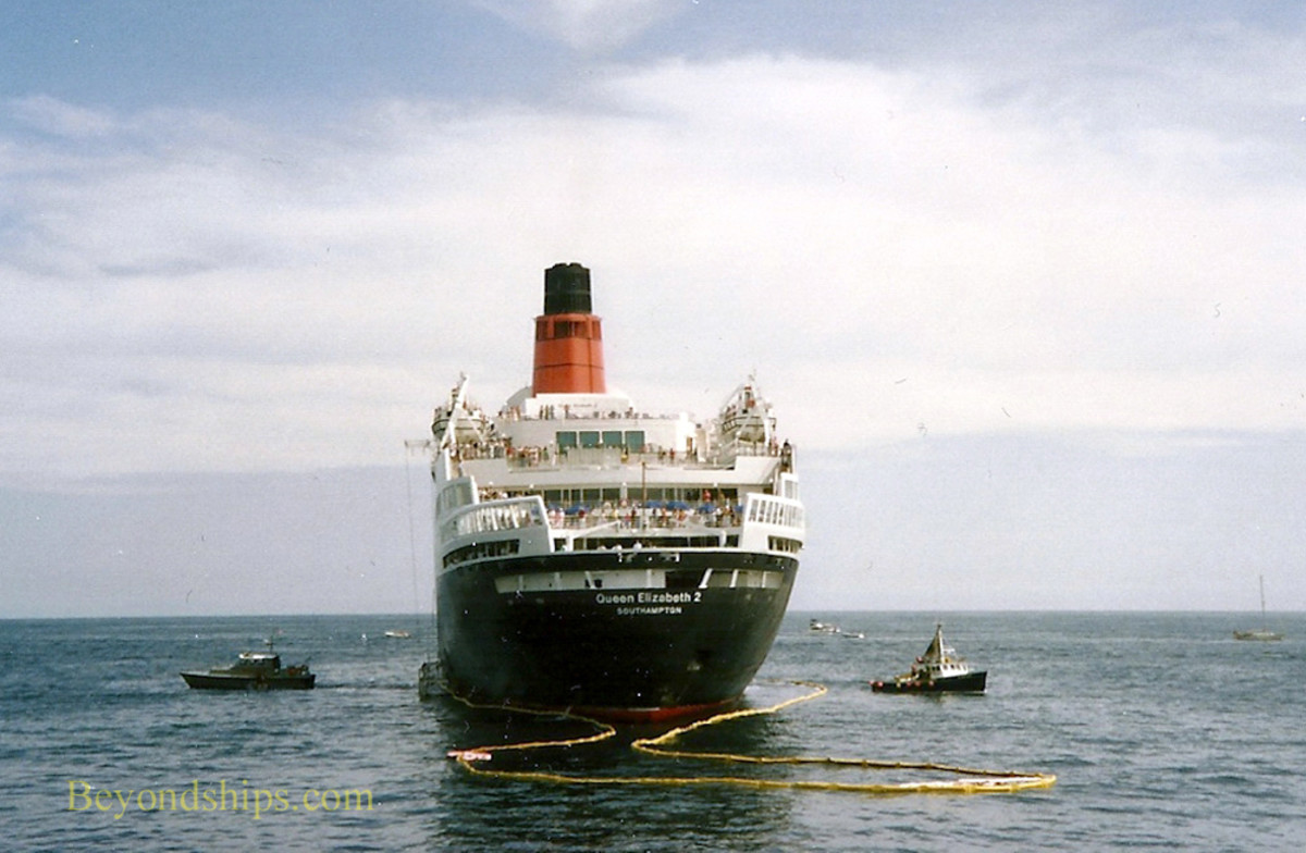 The QE2 aground. notice the yellow oil slick barrier that surrounds her. 