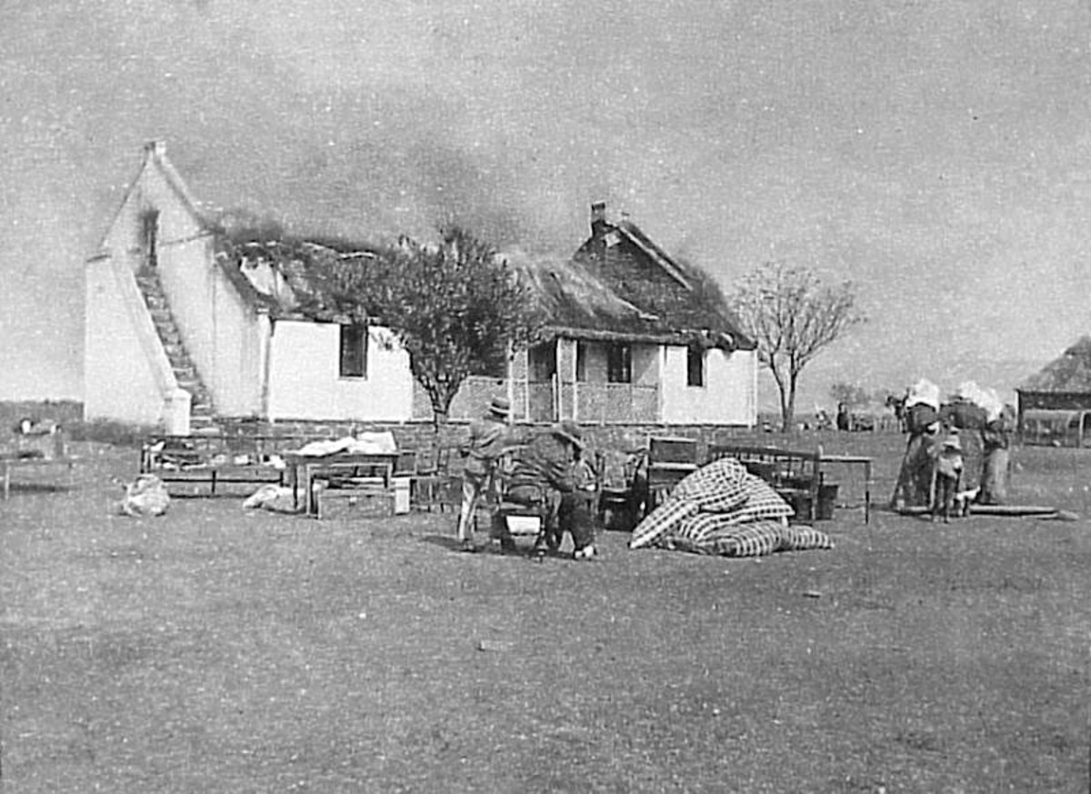 One British response to the guerrilla war was a 'scorched earth' policy to deny the guerrillas supplies and refuge. In this image Boer civilians watch their house as it is burned.