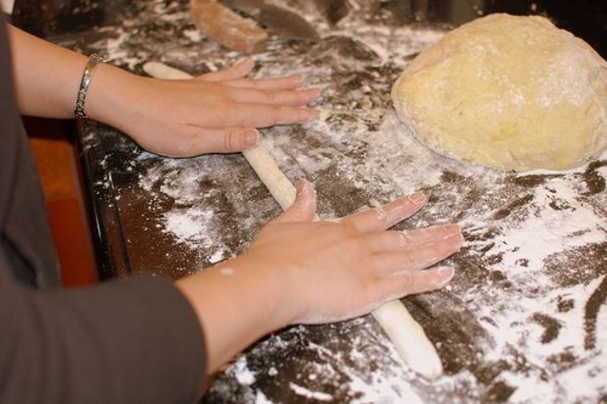 Rolling dough to form cursive letters.