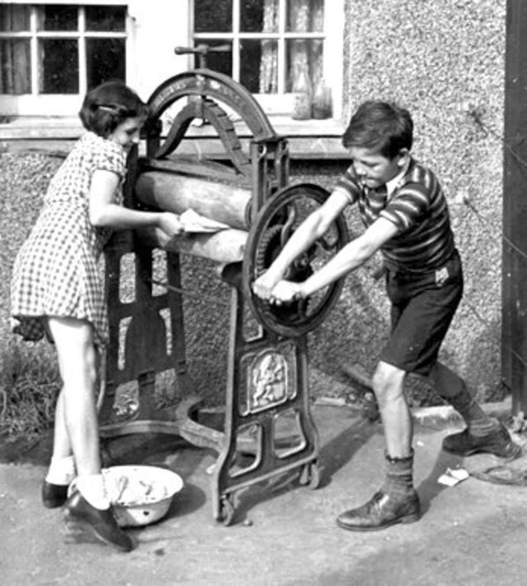 Mangling The Washing 13th September 1941: Peter and Pam putting washing through the mangle to wring it dry for their mother. Original Publication: Picture Post - 859 - The Life Of An Airman's Wife - pub. 1941 (Photo by Kurt Hutton / Picture Post / Ge