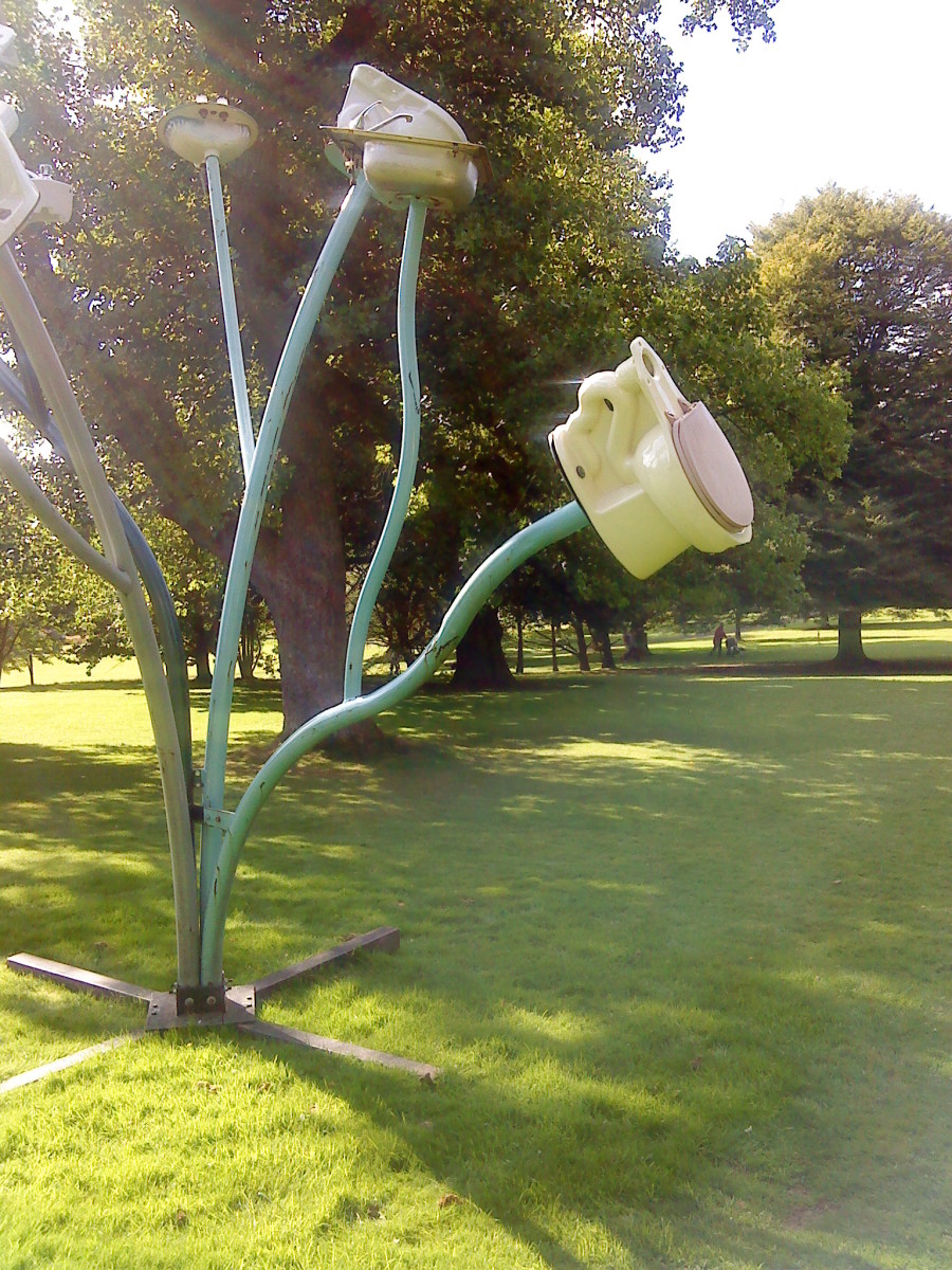 A toilet seat suspended from a metal branch. An example of modern sculpture. Dennis Oppenheim the sculptor.