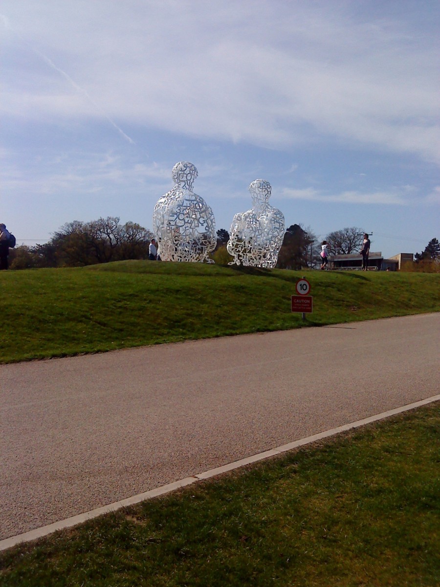 Jaume Plensa. Two seated giant males made of metal letters.